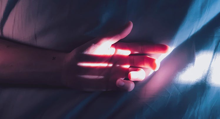 man's palm resting on a mattress - article header for sex toy for couples