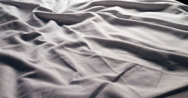 A close-up of wrinkled grey bedsheets