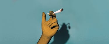 Hand holding a joint with a shadow that show drooping sperm.