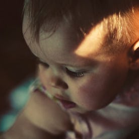 3-month-old baby looking over parent's shoulder.