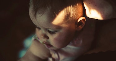 3-month-old baby looking over parent's shoulder.