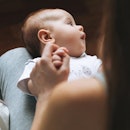 Infant looking away with eyes closed.