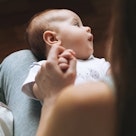 Infant looking away with eyes closed.