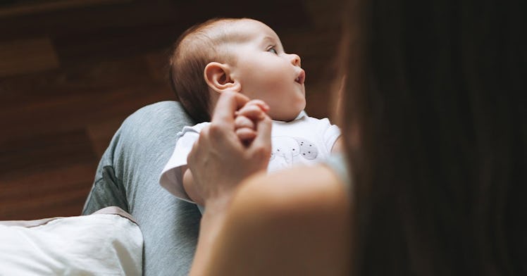 Infant looking away with eyes closed.