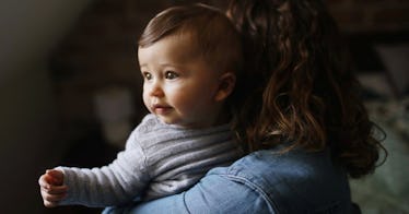 Baby looking over her mother's shoulder.