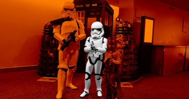 A family in Halloween costumes with an orange color filter with a boy in a Star Wars Stormtrooper co...