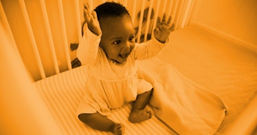 orange edit of a baby sitting up in a crib and raising their hands above their head