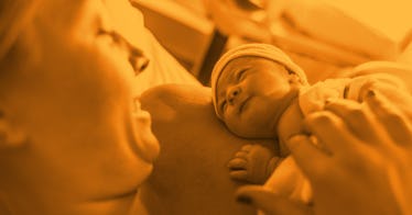 A mother lays down, holding a newborn on her chest.