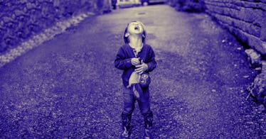 A child stands in a street, throwing a tantrum.