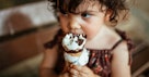 Toddler eating a dipped ice cream cone.