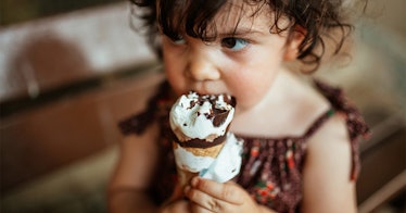 Toddler eating a dipped ice cream cone.