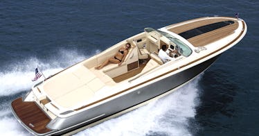 A man driving a luxury boat in the middle of the sea