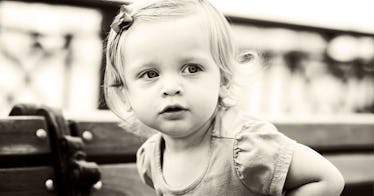 A child sits on a bench.