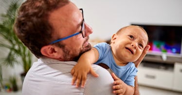 A father holding his crying toddler during parent coaching