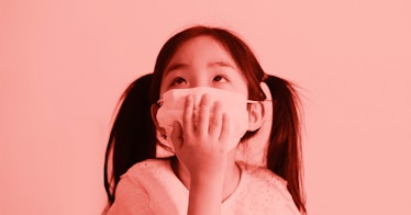 A small girl wearing a smoke mask for kids and looking up