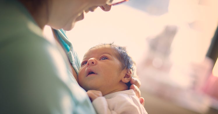 Newborn baby looking up at mother