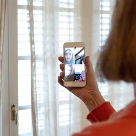 A woman on a video call with two friends during an epidemic