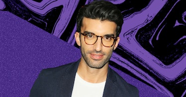 Justin Baldoni in a white shirt and black blazer wearing glasses with an abstract purple-black backg...