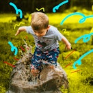 A little boy happily playing in the mud