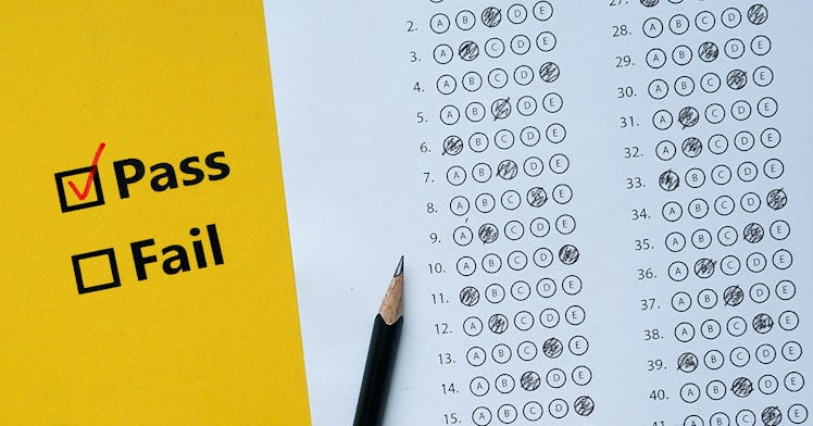 A pencil next to a filled out multiple choice quiz with the words pass and fail next to it