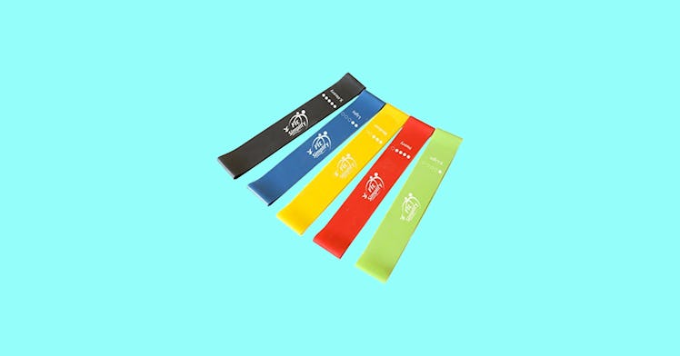 Black, blue, yellow, red, and green exercise bands on a bright blue background