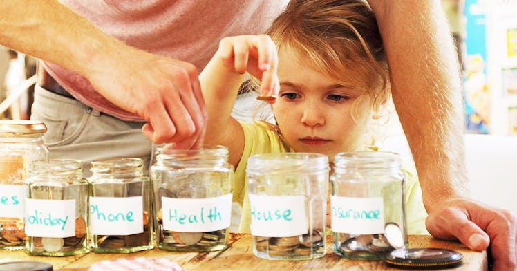 a kid puts coins into a piggy bank