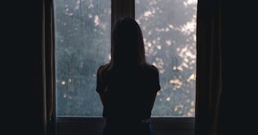 A child in shadow in front of a window.