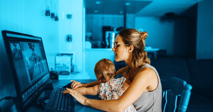 Stressed-out mom working on her computer, with her daughter in her lap, trying to stay centered with...
