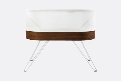 The Snoo Smart Sleeper Bassinet by Happiest Baby in white with a wooden bottom 