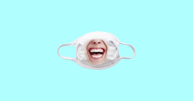 funny face mask decorated with photo of smiling mouth isolated on aqua blue background