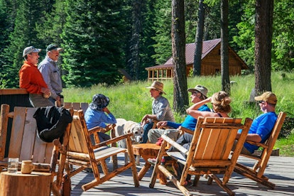 Guests sitting and talking together on the terrace of Minam River Lodge, Eagle Cap Wilderness in Ore...
