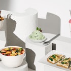 five different meals for kids placed on various white platforms