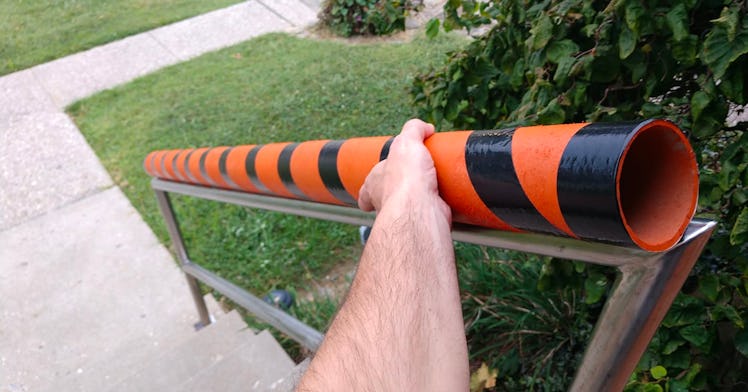 mans hand holding a orange and black striped candy chute