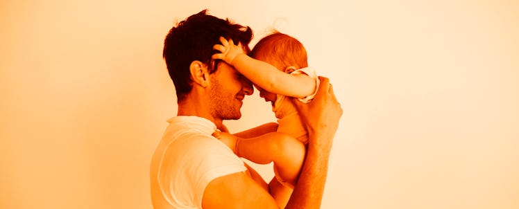 A man holding his daughter, touching foreheads