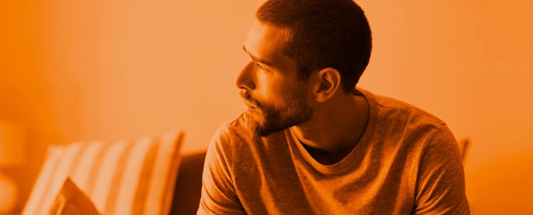 A man sitting down looking to the side, thinking about his journey with addiction recovery