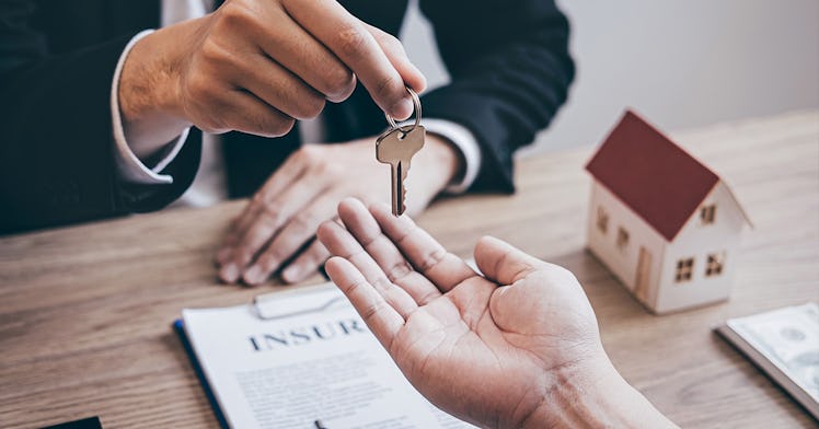 A realtor handing keys to another man after closing on a house