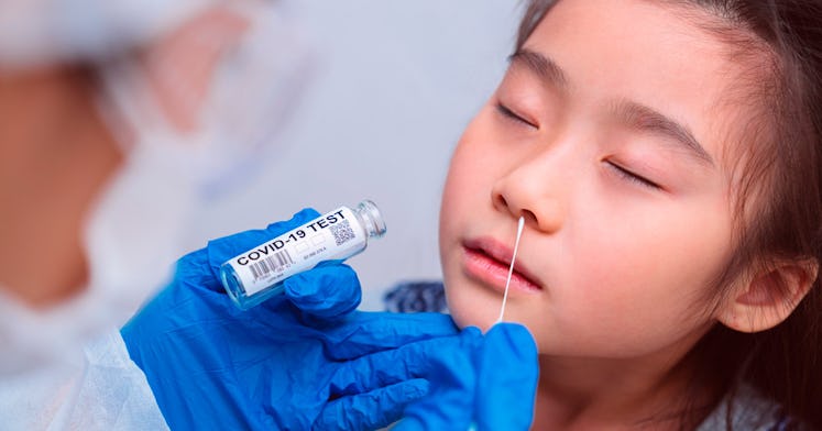 doctor inserting a covid test nasal swab into a child's nose