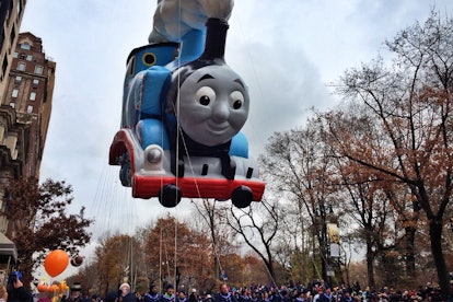 A balloon of Thomas the Tank Engine floats above the trees at the 2014 Macy's Thanksgiving Day Parad...
