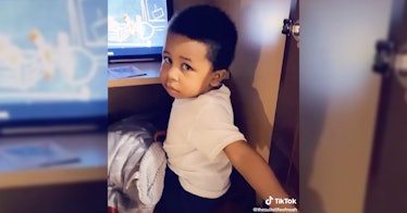 Screenshot of toddler hiding in kitchen cabinet