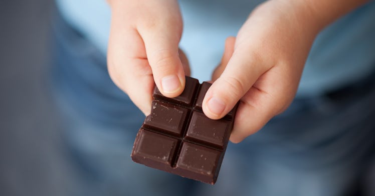 A pair of kid's hands hold a chocolate bar
