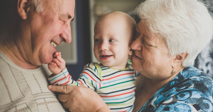 grandma and grandpa -- happy grandparents by any nickname -- cuddle their grandchild