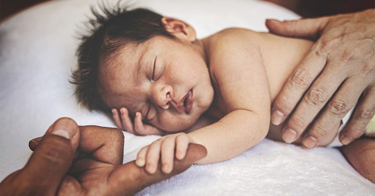 Newborn holds parent's hand