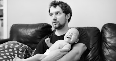 unsure man holding crying infant