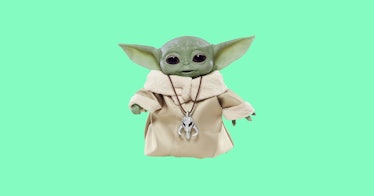 Baby Yoda doll against a mint green background