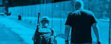 A father and a son approaching a baseball court as the boy is about to attend his baseball training ...