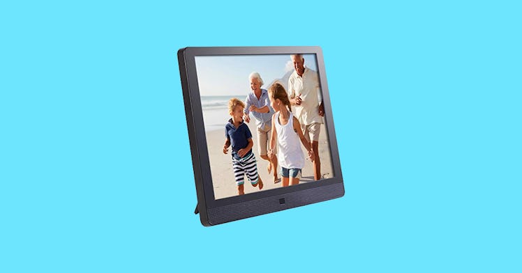 A digital picture frame displaying an image of grandparents and grandkids, set against an aqua backg...