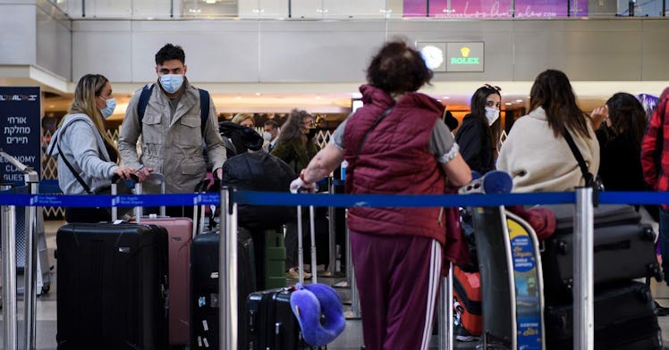 Airport travelers wear face masks