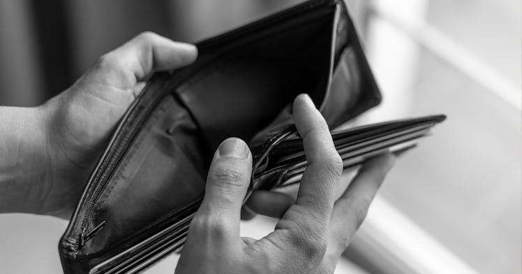 A hand holds open a bill-fold in black and white