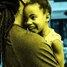 blue tint edit of dad holding smiling 5-year-old daughter