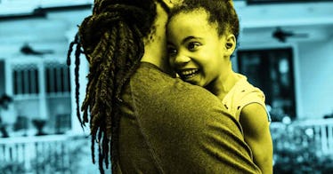 blue tint edit of dad holding smiling 5-year-old daughter